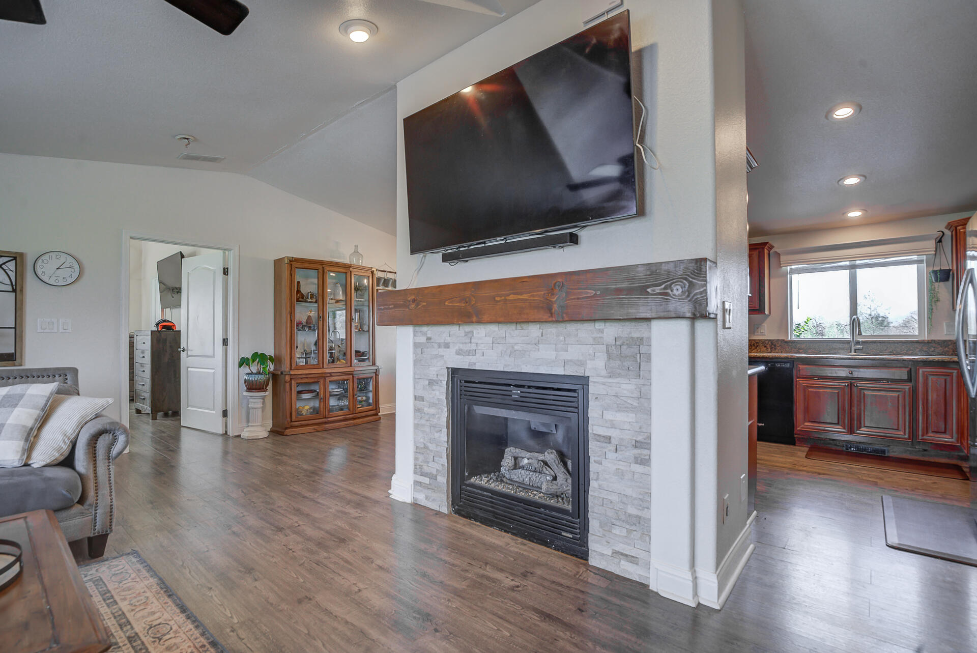 11636 Homestead Lane Redding, CA 96003 - Photo 5 of 37 a living room with furniture a flat screen tv and a fireplace