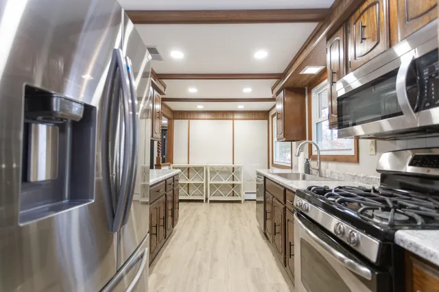 a kitchen with stainless steel appliances granite countertop a stove a refrigerator and cabinets