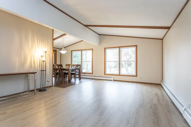 an empty room with wooden floor and furniture