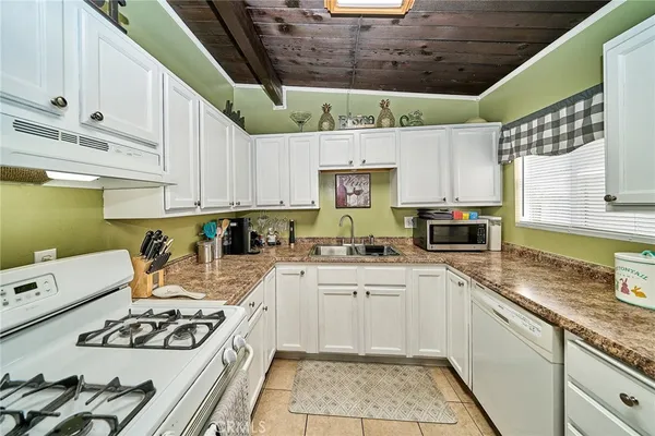 a kitchen with stainless steel appliances granite countertop a sink a stove and cabinets