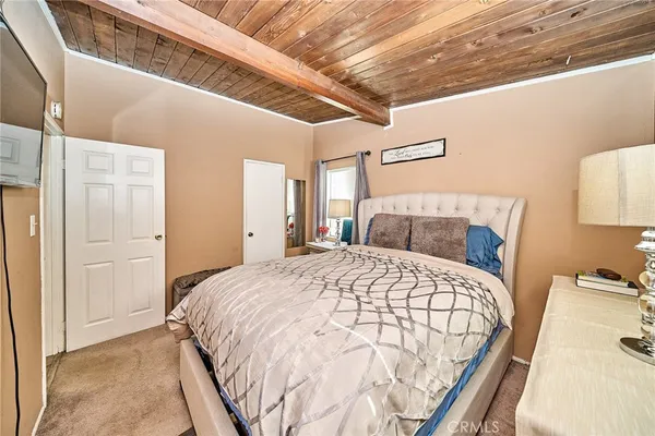 a bedroom with a bed and a lamp on dresser