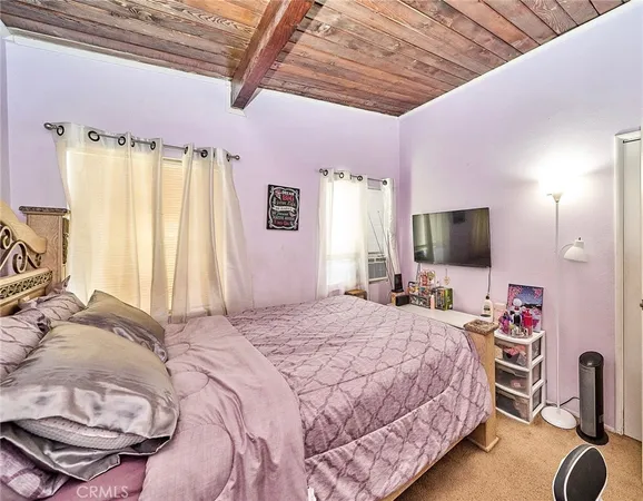 a bedroom with a bed window and a flat screen tv
