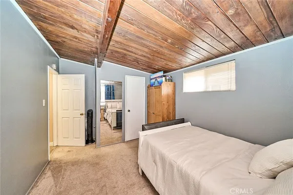 a spacious bedroom with a bed and a chandelier