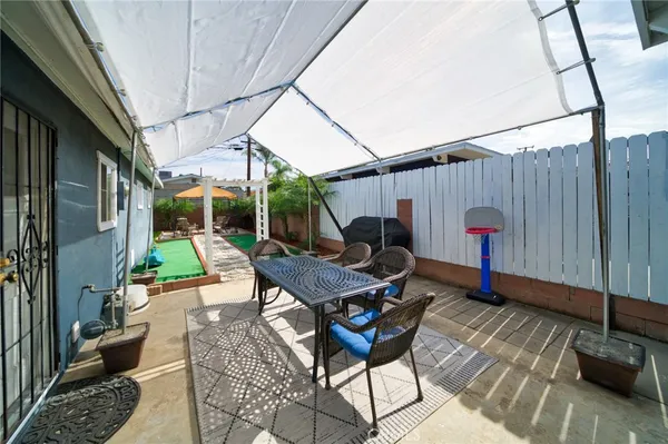 a view of backyard with table and chairs and potted plants
