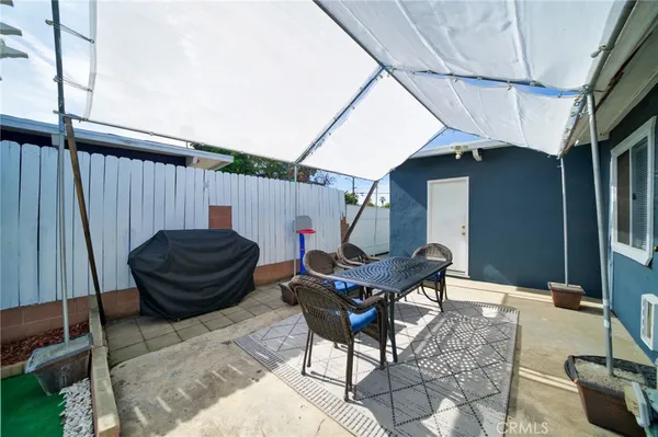 a backyard of a house with table and chairs