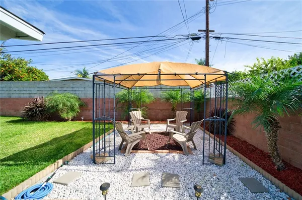 a patio with table and chairs and potted plants