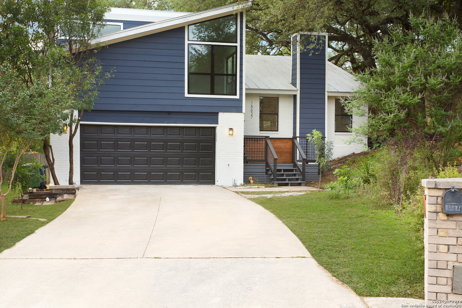 a front view of a house with a garden