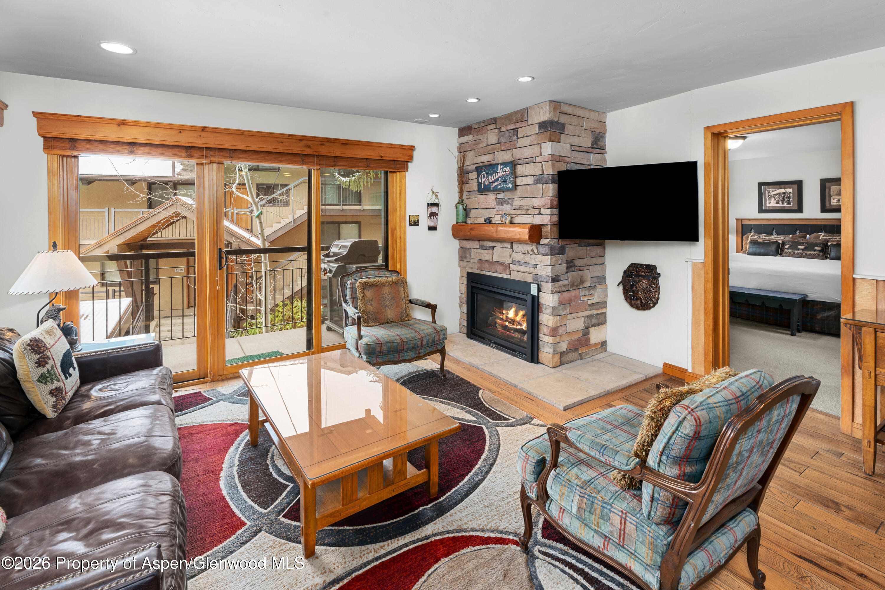 400 Wood Road, Unit 2111H Snowmass Village, CO 81615 - Photo 4 of 16 a living room with furniture a flat screen tv and a fireplace