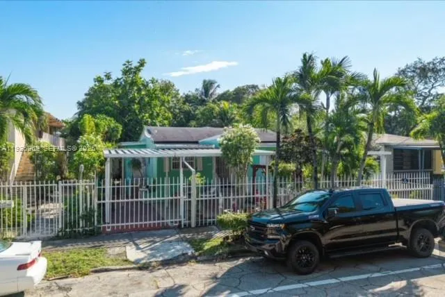 a view of a car parked in back yard of a house
