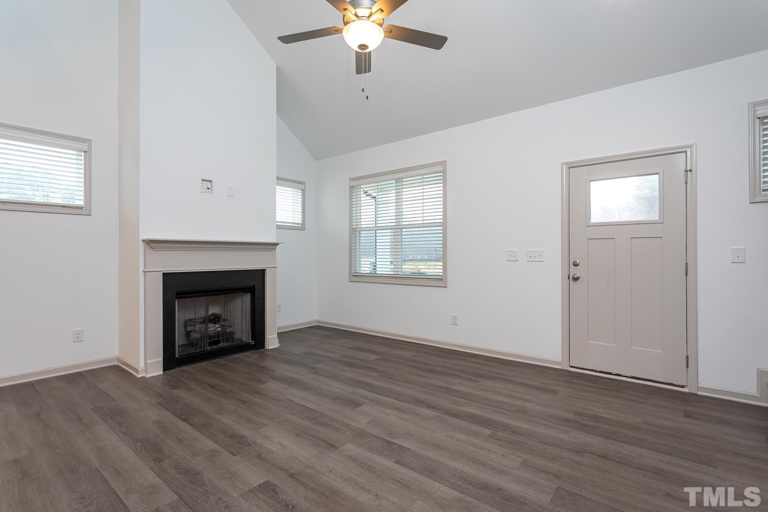 749 Hadstock Path Zebulon, NC 27597 - Photo 11 of 25 wooden floor fireplace and windows in an empty room