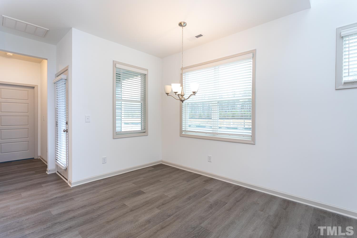 749 Hadstock Path Zebulon, NC 27597 - Photo 12 of 25 an empty room with wooden floor and windows
