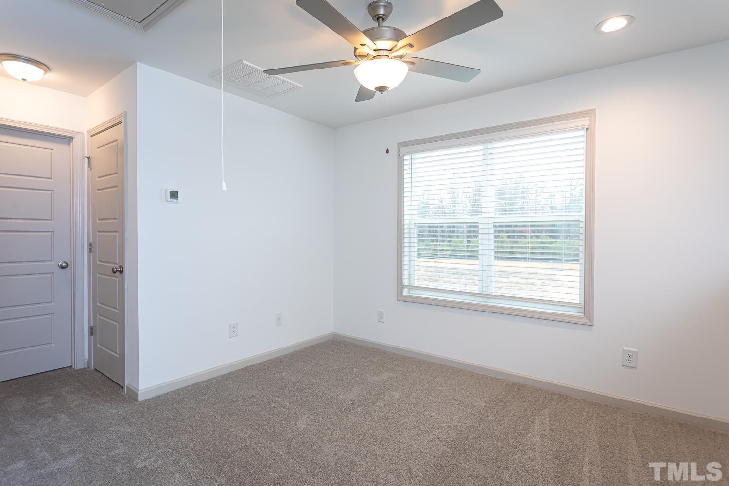 749 Hadstock Path Zebulon, NC 27597 - Photo 17 of 25 an empty room with a window and a fan