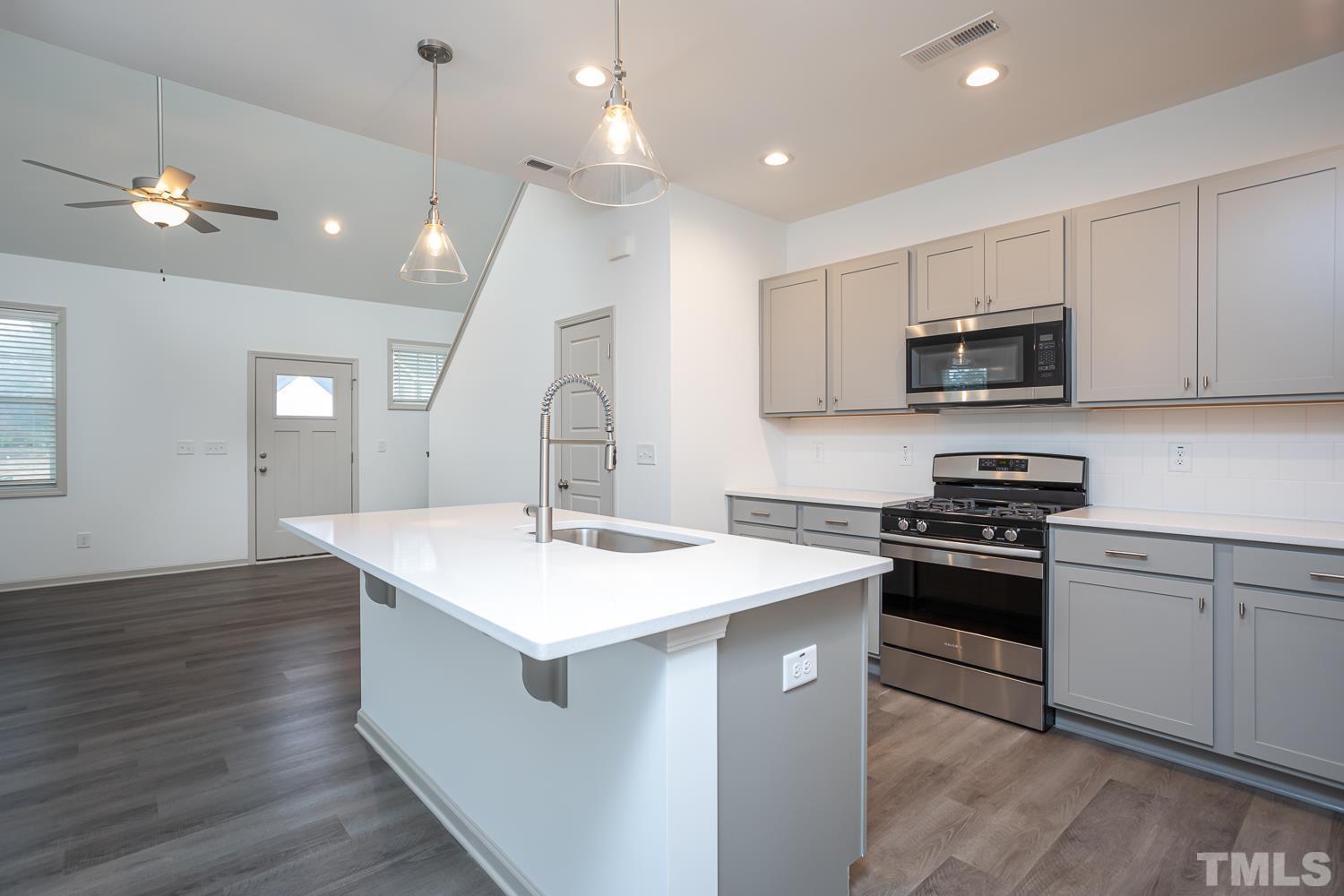 749 Hadstock Path Zebulon, NC 27597 - Photo 6 of 25 a kitchen with a sink a stove a microwave and cabinets