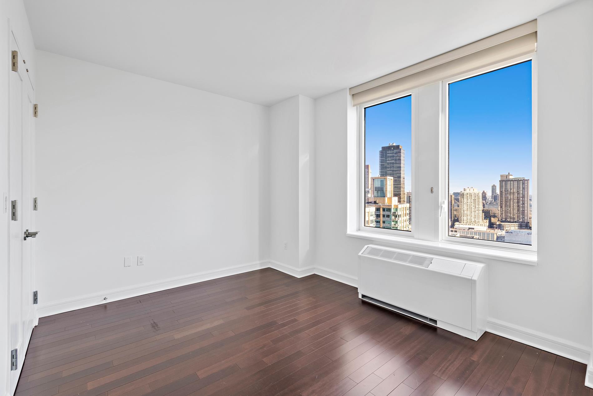 80 Riverside Boulevard, Unit 37B Manhattan, NY 10069 - Photo 10 of 22 a view of an empty room with wooden floor and a window