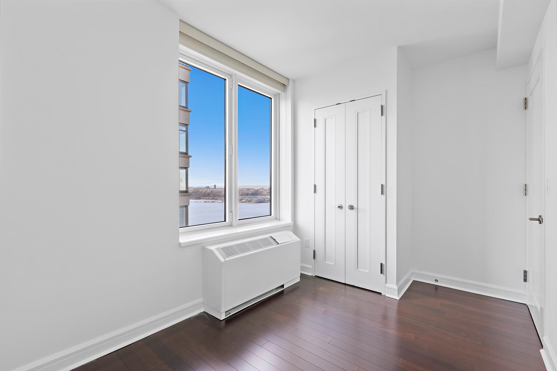 80 Riverside Boulevard, Unit 37B Manhattan, NY 10069 - Photo 12 of 22 a view of an empty room with wooden floor and a window