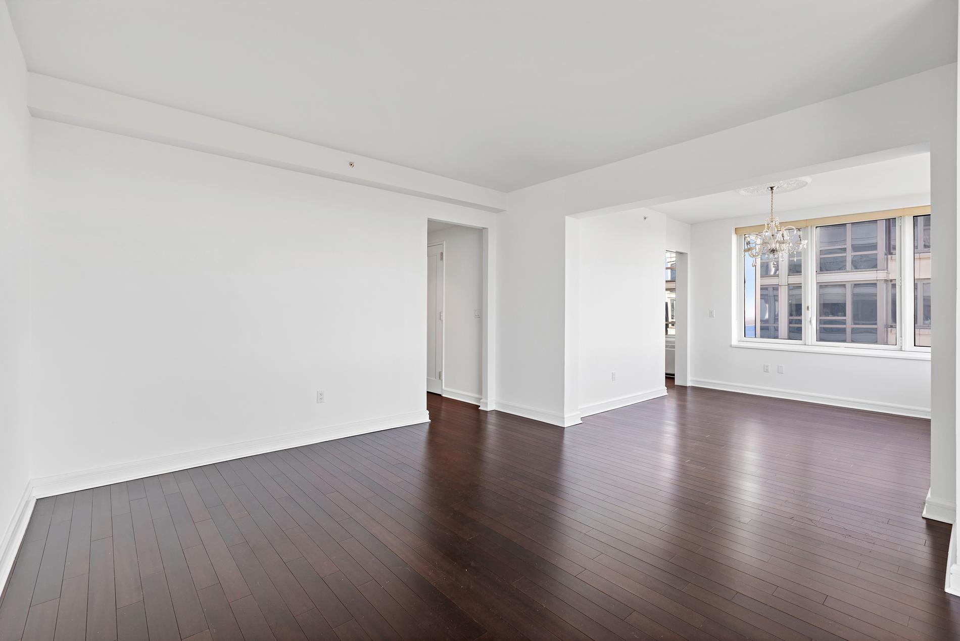 80 Riverside Boulevard, Unit 37B Manhattan, NY 10069 - Photo 18 of 22 a view of a livingroom with wooden floor and windows