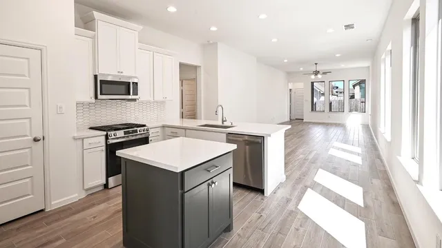 a kitchen with stainless steel appliances granite countertop a stove and a sink