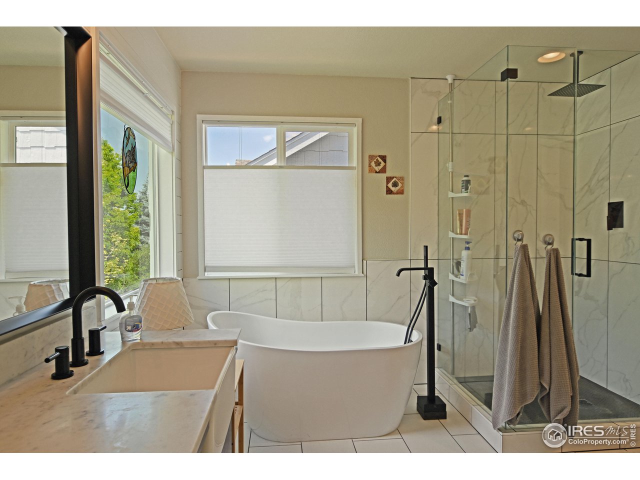 8113 Northstar Drive Windsor, CO 80528 - Photo 21 of 40 a bathroom with a tub a sink a mirror and a shower