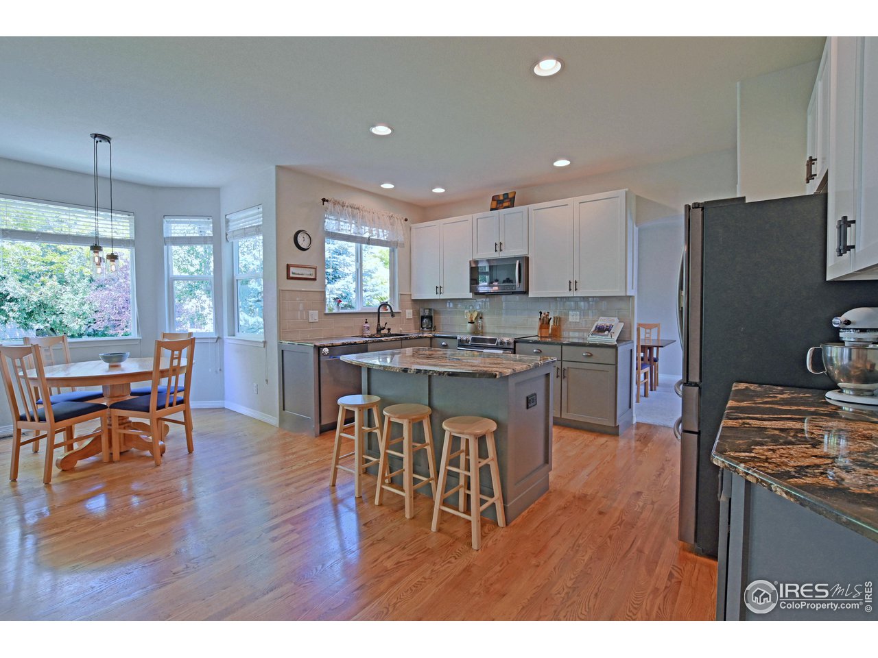 8113 Northstar Drive Windsor, CO 80528 - Photo 5 of 40 a kitchen with a table chairs refrigerator and cabinets