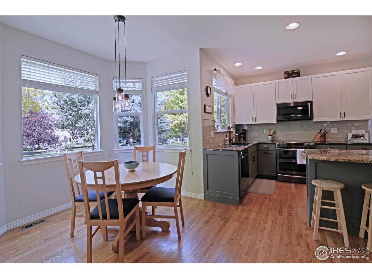 8113 Northstar Drive Windsor, CO 80528 - Photo 6 of 40 a kitchen with stainless steel appliances granite countertop a stove a refrigerator a kitchen island a table and chairs