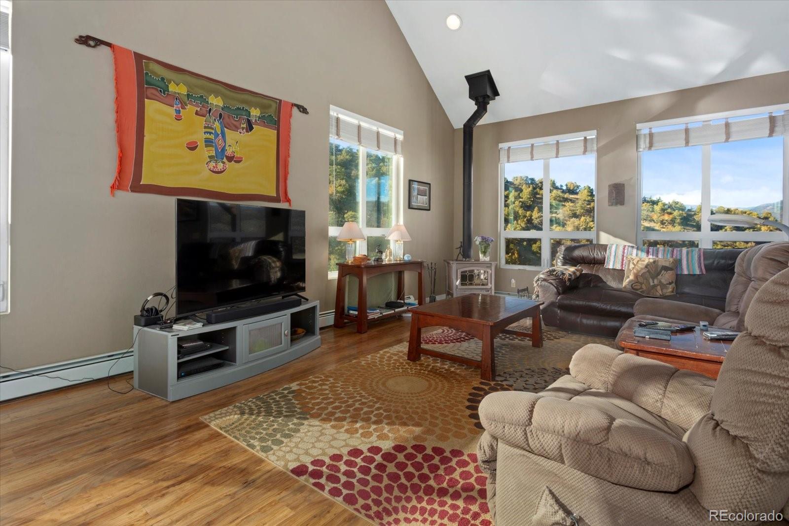 402 Trailridge Road Coaldale, CO 81222 - Photo 8 of 50 a living room with furniture a flat screen tv and a floor to ceiling window