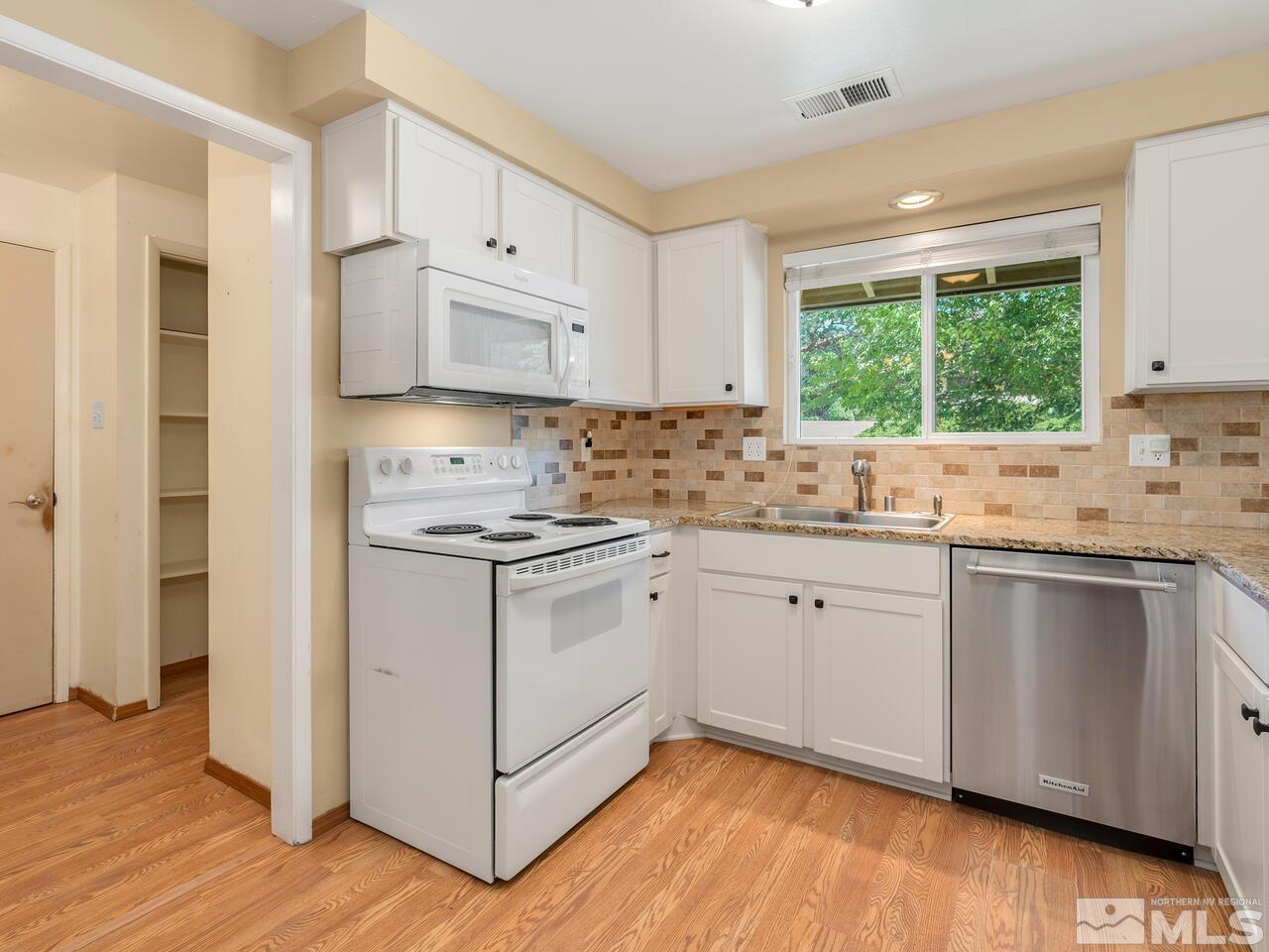 14015 Minnetonka Circle Reno, NV 89521 - Photo 6 of 22 a kitchen with stainless steel appliances white cabinets a sink and a stove