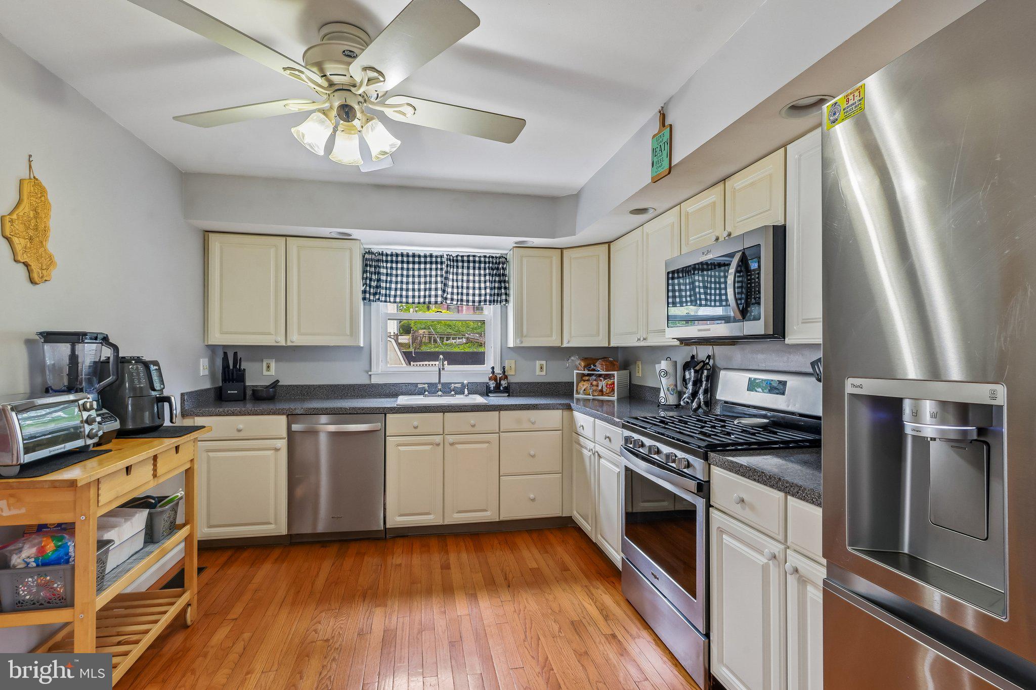 878 Crescent Avenue Runnemede, NJ 08078 - Photo 4 of 24 a kitchen with stainless steel appliances granite countertop a stove top oven a sink dishwasher a refrigerator with white cabinets and wooden floor