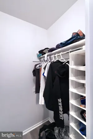 a view of walk in closet with clothes and shoes
