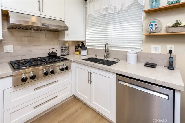 a kitchen with stainless steel appliances granite countertop a sink stove and cabinets