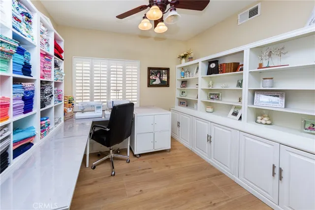 a view of a workspace with furniture and a window