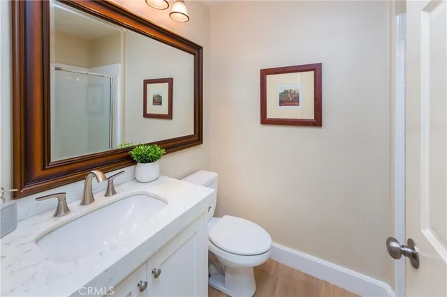 a bathroom with a granite countertop toilet a sink and mirror