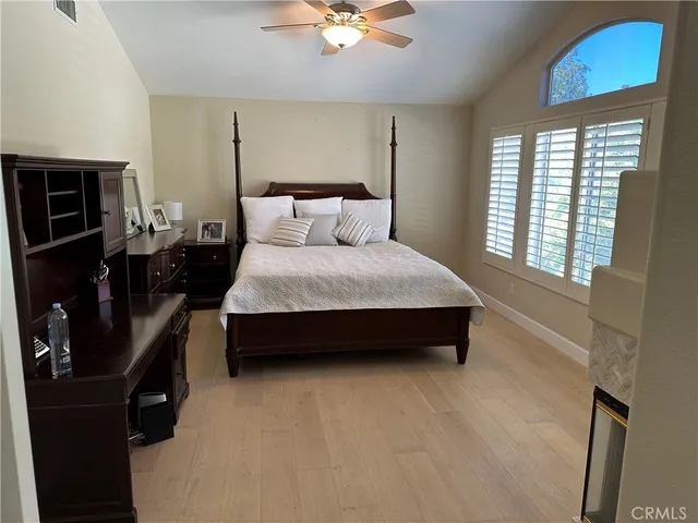 a spacious bedroom with a bed a window and dresser