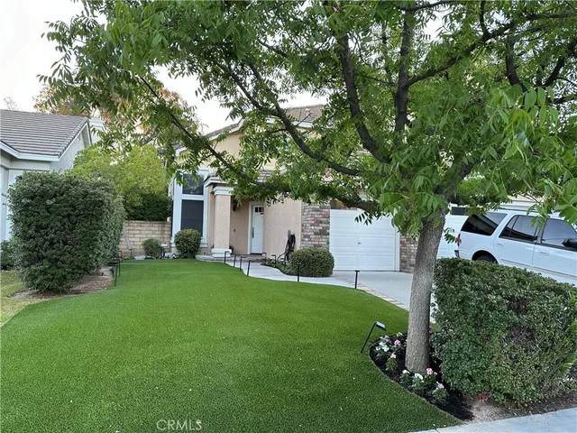 a front view of a house with a yard and trees