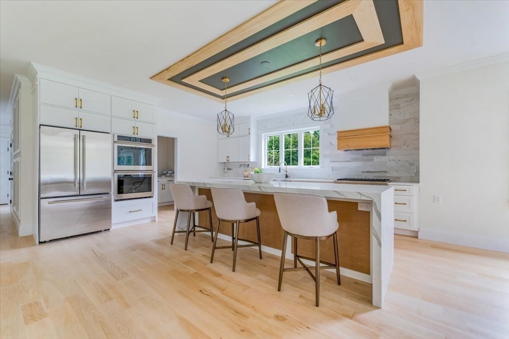 103 Center Street Hanover, MA 02339 - Photo 12 of 42 a kitchen with granite countertop a counter space dining table and stainless steel appliances