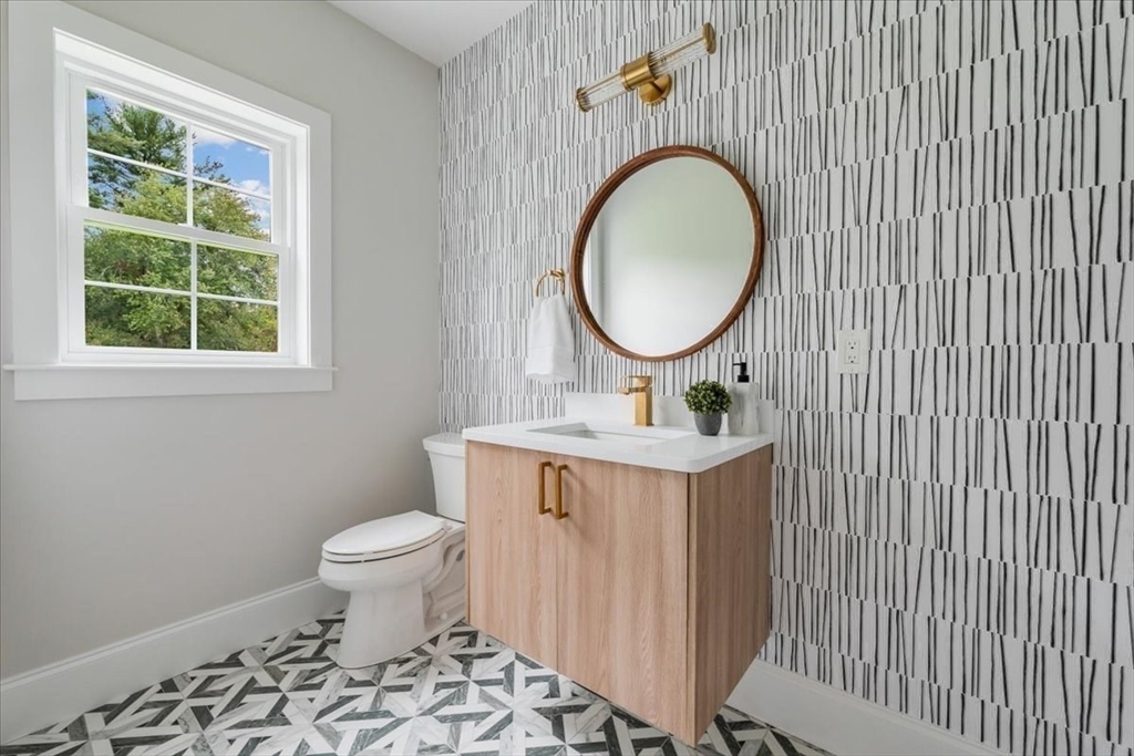 103 Center Street Hanover, MA 02339 - Photo 17 of 42 a bathroom with a granite countertop toilet a sink and a mirror