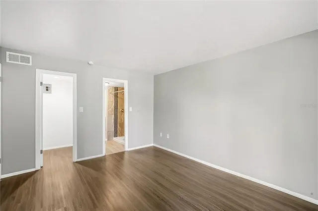 a view of an empty room with wooden floor