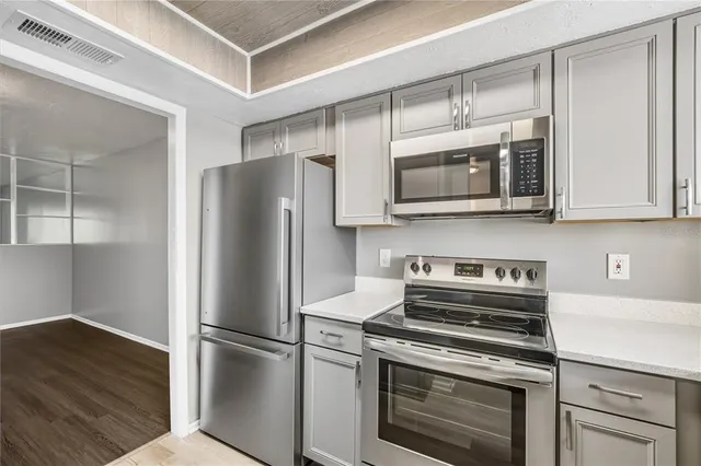 a kitchen with stainless steel appliances a stove microwave and refrigerator