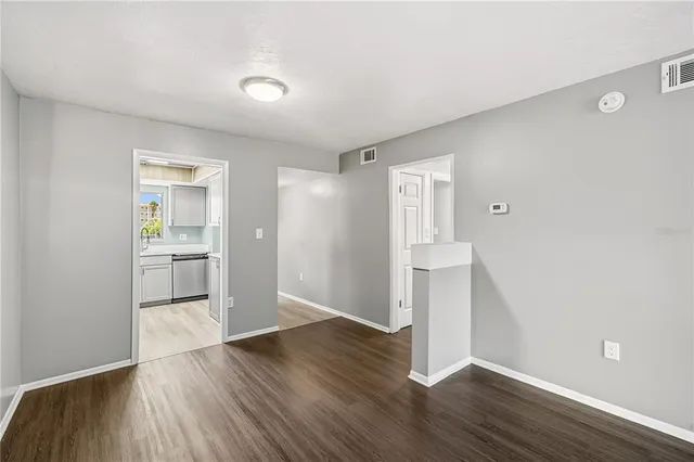 a view of a hallway with wooden floor and a bathroom