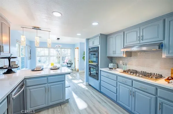 a kitchen with kitchen island granite countertop a sink cabinets and window