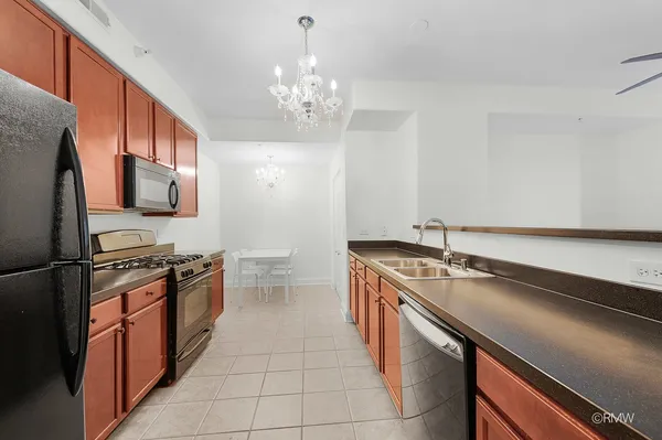 a kitchen with granite countertop a stove a sink and a microwave