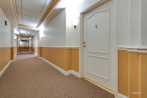 a view of a hallway with wooden cabinets