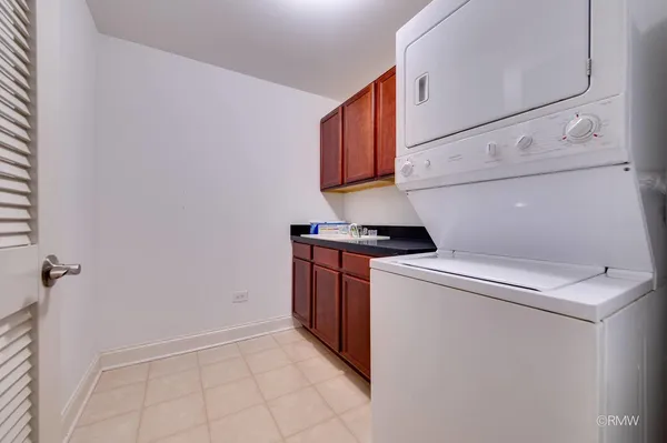 a large white kitchen with cabinets a sink and dishwasher