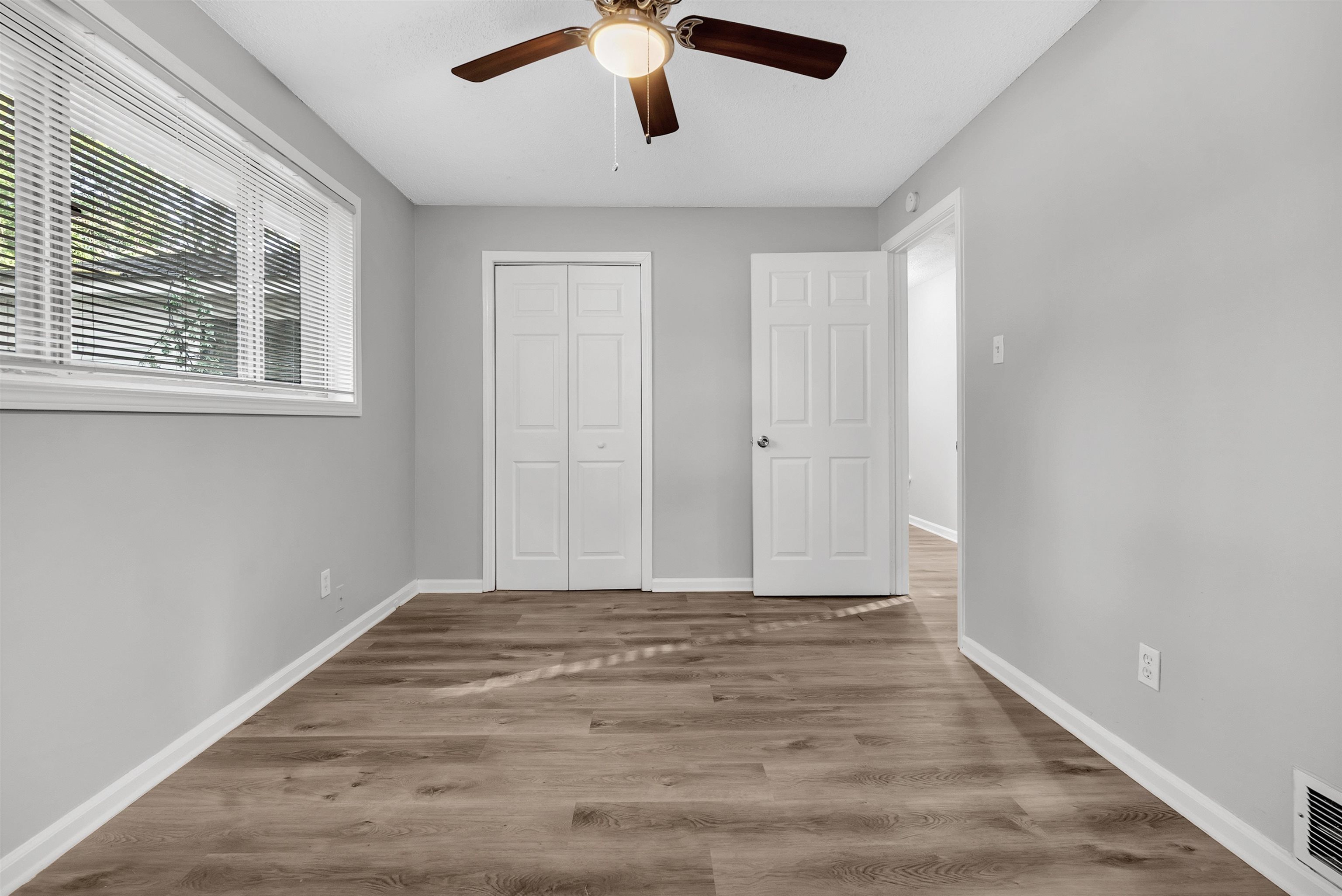 1136 South White Station Road Memphis, TN 38117 - Photo 4 of 19 a view of an empty room with wooden floor and a window