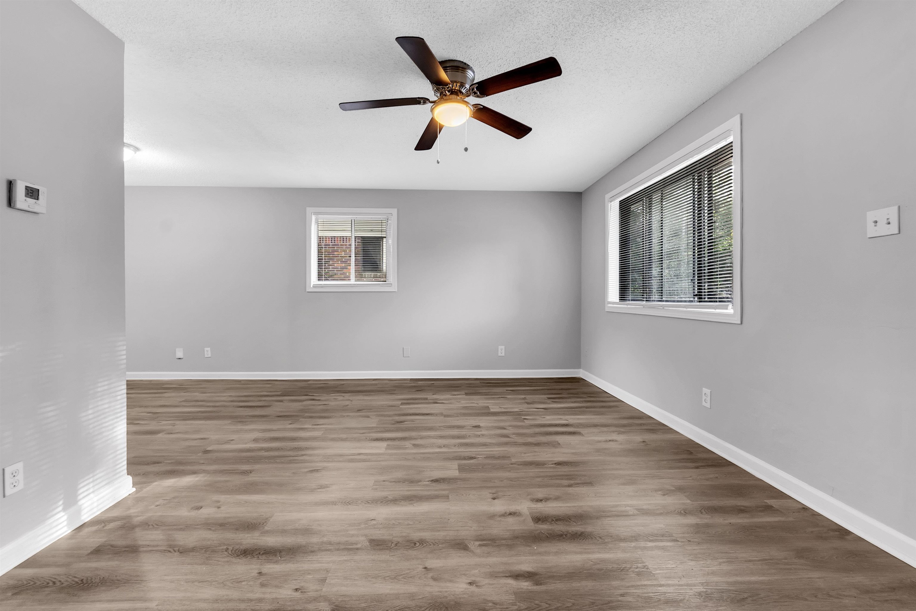 1136 South White Station Road Memphis, TN 38117 - Photo 7 of 19 a view of an empty room with wooden floor and a ceiling fan