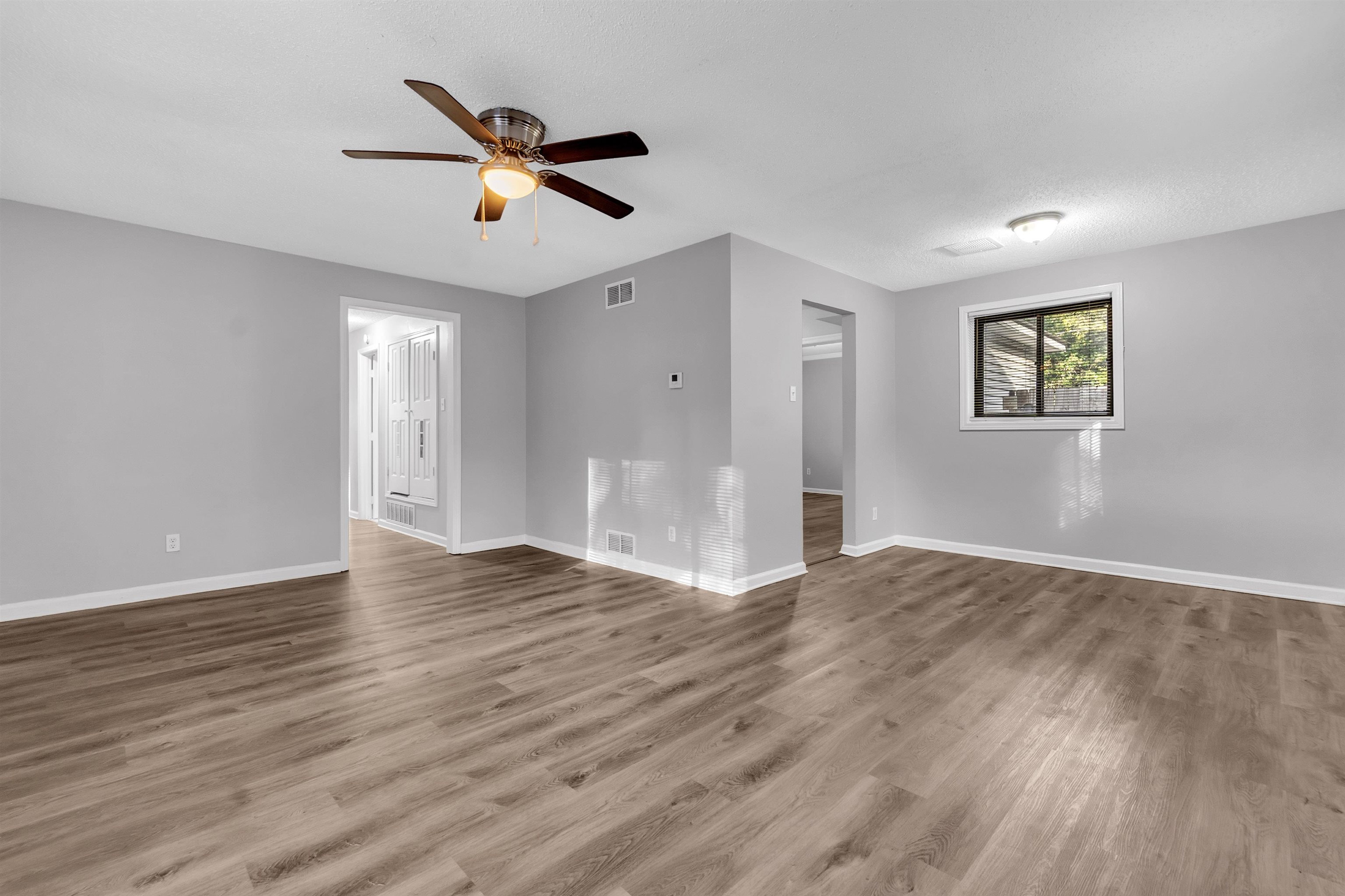 1136 South White Station Road Memphis, TN 38117 - Photo 10 of 19 a view of an empty room with wooden floor and a ceiling fan