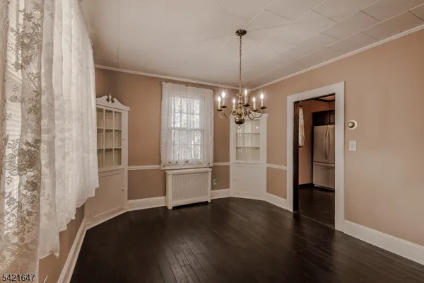 a view of a room with wooden floor chandelier and a window