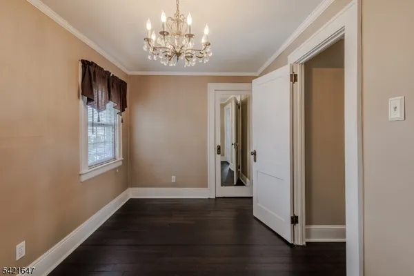 a view of a hallway with wooden floor and chandelier