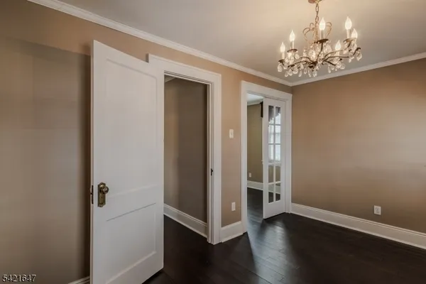 a view of a hallway with wooden floor and a chandelier