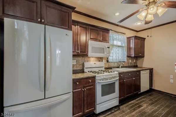 a kitchen with stainless steel appliances white cabinets and a stove top oven