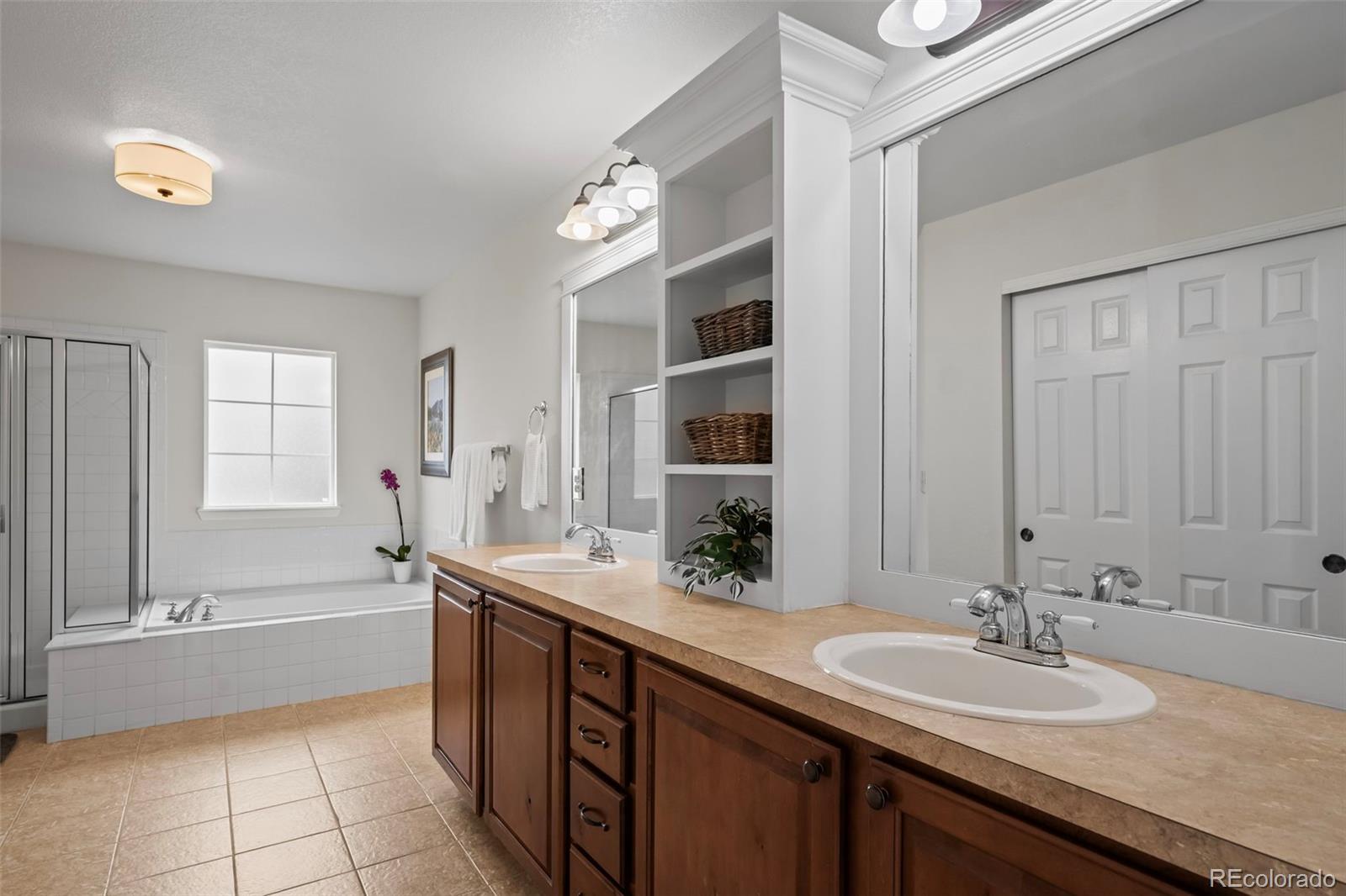4463 Eagle River Run Broomfield, CO 80023 - Photo 24 of 44 a bathroom with a granite countertop sink mirror and a bathtub